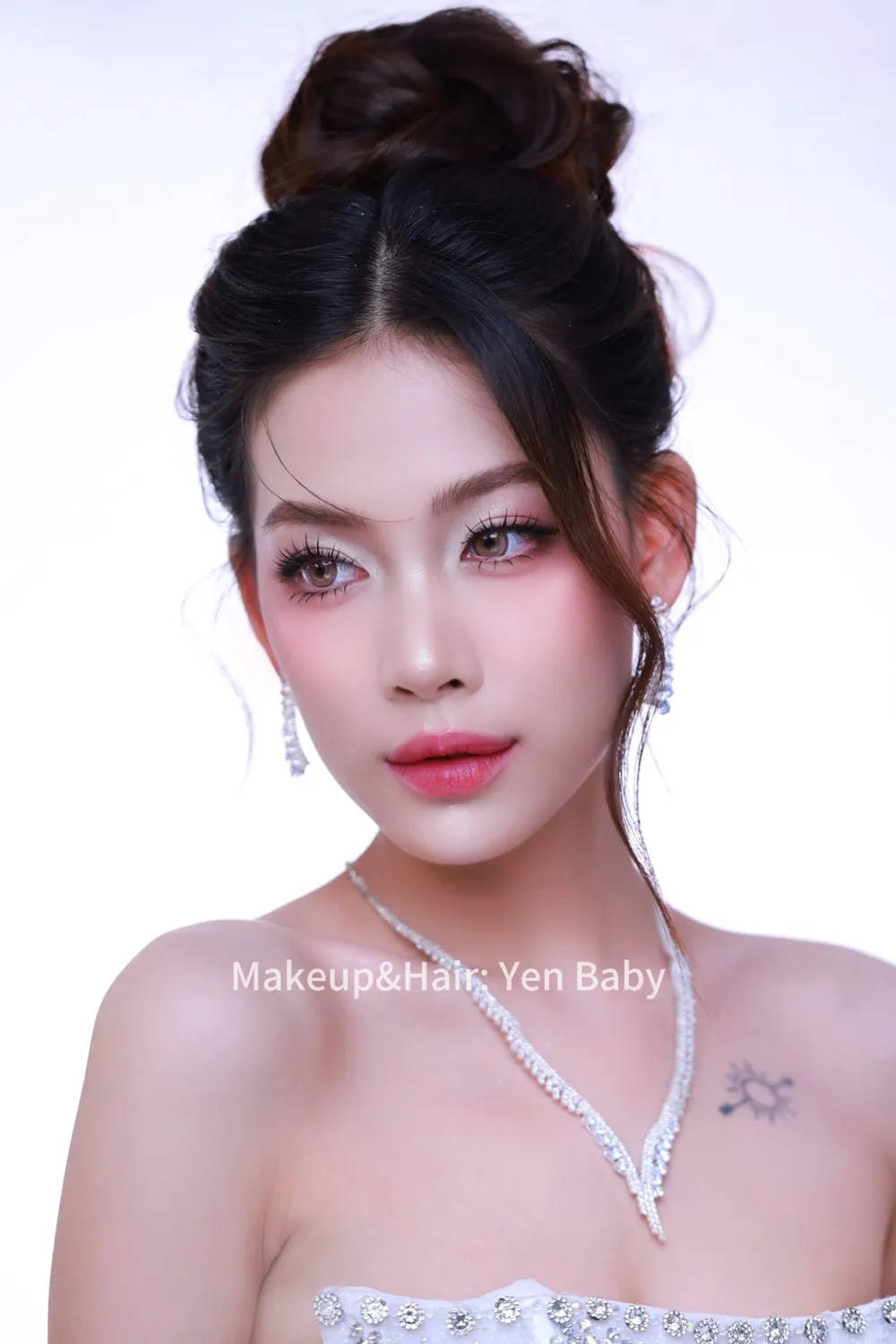 Cô dâu tóc búi cao nhìn thẳng, mắt kẻ sắc mi cong, môi hồng căng bóng
